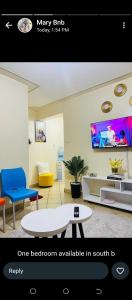 a living room with a couch a table and a tv at Hadassah apartment in Nairobi
