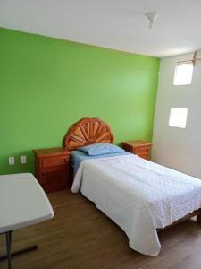 a bedroom with a bed and a green wall at Fresnos 14 Queretaro in Mendiola