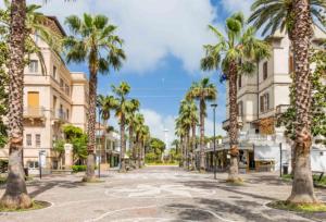 an empty street with palm trees and buildings at Villa Francesca Luxury - Adriatic Nature & Heritage House in Grottammare