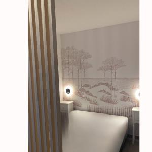 a room with two tables and a bed with trees on the wall at Charmant studio avec terrasse, front de mer et proche du centre in Saint-Raphaël