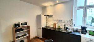 Una cocina con encimera negra y refrigerador. en Stacja Jeżyce, en Poznan 12 fotos más