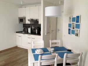 eine Küche mit Tisch und Stühlen und ein Esszimmer in der Unterkunft Haus Meeresblick - Ferienwohnung Am Strand (Ref. 128682u2) in Baabe