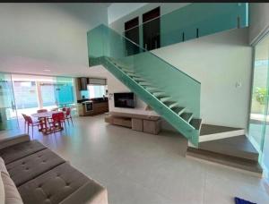 ein Wohnzimmer mit einer Treppe in einem Haus in der Unterkunft Casa de praia barra de São miguel in Barra de São Miguel