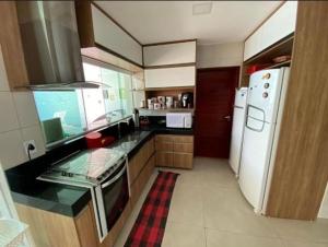 eine Küche mit Kühlschrank und Herd oberen Backofen in der Unterkunft Casa de praia barra de São miguel in Barra de São Miguel