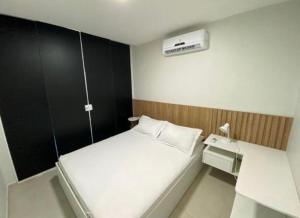 ein kleines Schlafzimmer mit einem weißen Bett und einer Heizung in der Unterkunft Casa de praia barra de São miguel in Barra de São Miguel + 27 Fotos