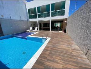 ein Gebäude mit einem Swimmingpool vor einem Gebäude in der Unterkunft Casa de praia barra de São miguel in Barra de São Miguel