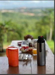 a picnic table with a thermos and a plate of food at Chalé da Lourdes in Santarém