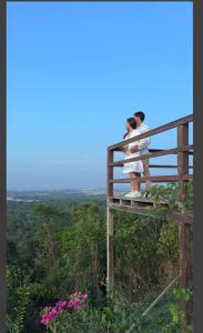 two people standing on top of a lookout tower at Chalé da Lourdes in Santarém +5 photos