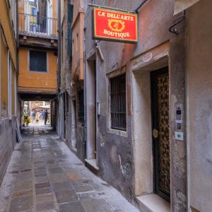 Un callejón con un cartel al costado de un edificio. en Cà dell'Arte Boutique, en Venecia