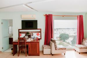 een kamer met een bureau, stoelen en een raam bij Art Deluxe Hotel in Nha Trang