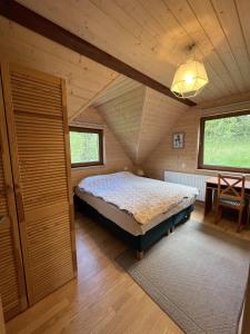 une chambre avec un lit dans un grenier dans l'établissement Borówka, à Zawóz