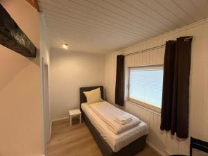 a small bedroom with a bed and a window at Ferienhaus in ruhiger Lage mit 2 Bädern in Neumünster