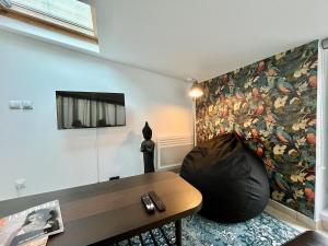 a living room with a large painting on the wall at Maison duplex, 2 chambres, terrasse en rooftop in Saint-Ouen