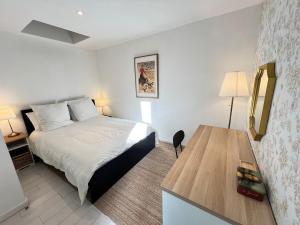 a hotel room with a bed and a desk at Maison duplex, 2 chambres, terrasse en rooftop in Saint-Ouen