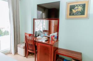 een kamer met een bureau en een spiegel bij Art Deluxe Hotel in Nha Trang