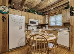 a kitchen with a table and a white refrigerator at A Smoky Getaway in Sevierville