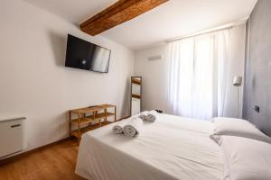 a bedroom with a white bed with towels on it at Emilia Studios 5 in Modena +11 photos