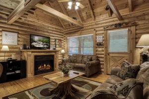 a living room with a fireplace in a log cabin at A Smoky Getaway in Sevierville