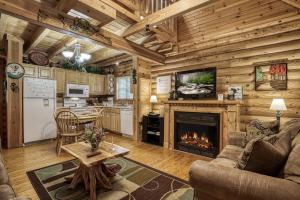 a living room with a fireplace in a log cabin at A Smoky Getaway in Sevierville +24 photos