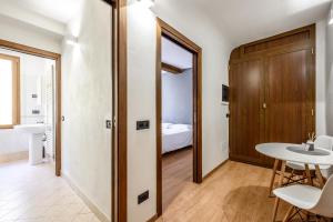 Habitación con puerta, mesa y cama en Emilia Studios 5, en Módena 1 foto más