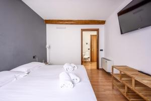 Un dormitorio con dos camas y un televisor de pantalla plana. en Emilia Studios 5, en Módena