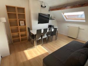 un soggiorno con tavolo da pranzo e sedie di European District Apartment Thirteen a Bruxelles