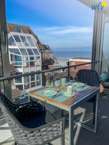 Una mesa en un balcón con vista al mar. en Haus Poseidon Ferienwohnung 4 1, en Wangerooge