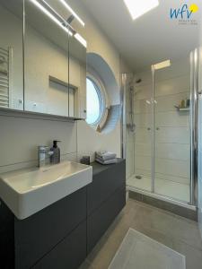 un baño con lavabo y ducha en Haus Poseidon Ferienwohnung 4 1, en Wangerooge