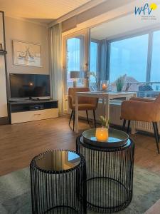 Una sala de estar con una mesa y un comedor. en Haus Poseidon Ferienwohnung 4 1, en Wangerooge