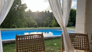 a couple of chairs sitting next to a swimming pool at Mas des Gémeaux in Ménerbes