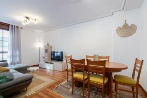 a living room with a table and chairs and a couch at Con parking y para 6 huéspedes by CABANA Rentals in Cangas de Morrazo