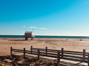 a wooden fence on a beach with the ocean at Bas de Chalet Santa Giulia in Gruissan