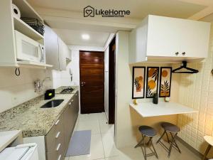 a kitchen with a sink and two stools in it at Mar Bello in Ilha da Restinga