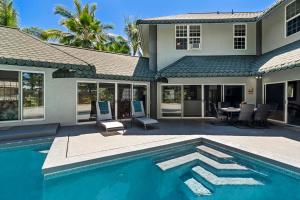 a house with a swimming pool in front of a house at Kokua at Kona Bay Estates in Kailua-Kona