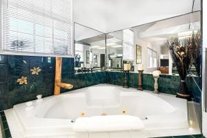 a white bath tub in a bathroom with a mirror at Kokua at Kona Bay Estates in Kailua-Kona +47 photos
