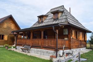 a large wooden house with a gambrel roof at Zlatiborsko srce in Čemerikovci