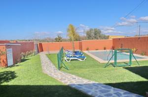 un patio con un parque infantil con un columpio en Casa Nispero, en Conil de la Frontera