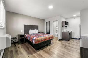 a hotel room with a bed and a desk at Southern Suites Forest Park in Forest Park