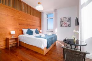 a bedroom with a bed with a wooden wall at Casa Formosa - HOST & CHILL in Porto Formoso