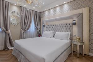 Un dormitorio con una gran cama blanca y una lámpara de araña. en Cà dell'Arte Boutique, en Venecia