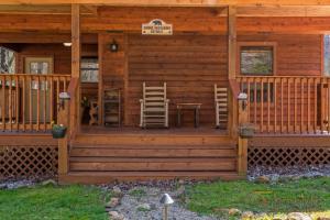 a log cabin with a table and chairs on the porch at Bear Run in Sevierville