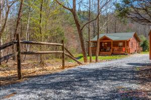 a cabin in the woods next to a fence at Bear Run in Sevierville