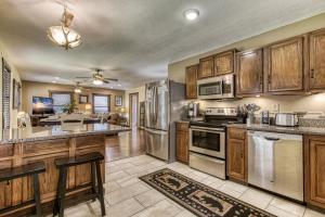 a kitchen with wooden cabinets and stainless steel appliances at Bear Run in Sevierville +28 photos