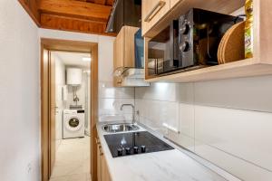 une cuisine avec un évier et une machine à laver dans l'établissement Urban Escape Cottage, à Ljutomer