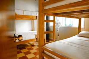 a bedroom with two bunk beds and a checkered floor at Lucca Hostel Medellín in Medellín +100 photos