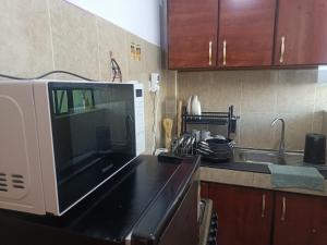 a kitchen with a microwave and a sink at Kings & Queens Arena in Nairobi