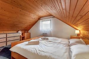 une chambre avec un grand lit avec un plafond en bois dans l'établissement Urban Escape Cottage, à Ljutomer