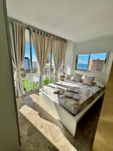 een slaapkamer met een groot bed en grote ramen bij Loft beach in Alicante +28 foto's