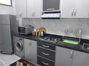 a kitchen with a sink and a stove and a microwave at Casa Salvador 1 boujdour in Cabo Bojador +15 photos