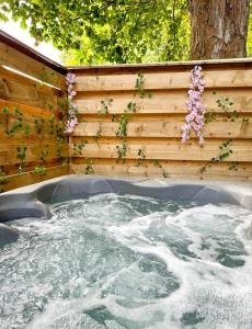 a hot tub with flowers on a wooden wall at Boann 5 - Hot Tub-Hunting Tower Lodges-Luxury-Families-Romantic in Perth